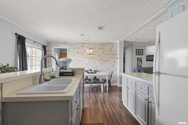 102 E Woolcott St, Harrisburg, IL 62946 - kitchen featuring light countertops, visible vents, a sink, freestanding refrigerator, and dark wood-style flooring