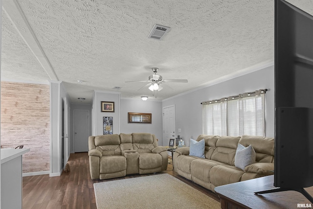 102 E Woolcott St, Harrisburg, IL 62946 - living area featuring dark wood-style floors, visible vents, a ceiling fan, crown molding, and a textured ceiling