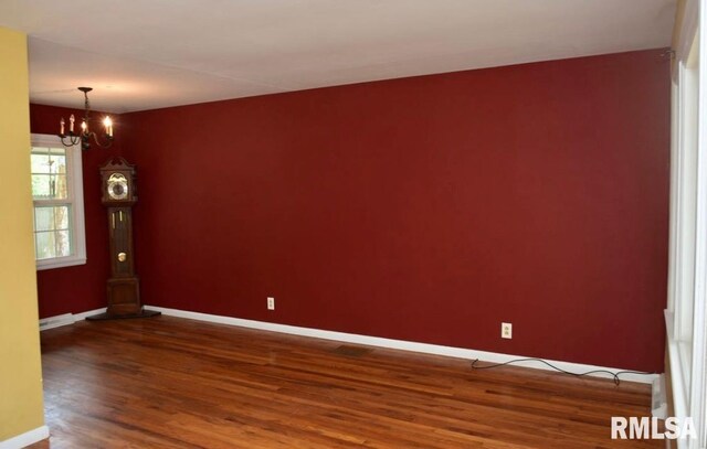 1001 S Emerald Ln, Carbondale, IL 62901 - empty room with baseboards, a notable chandelier, and wood finished floors