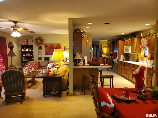 kitchen featuring light countertops, white appliances, recessed lighting, and hanging light fixtures