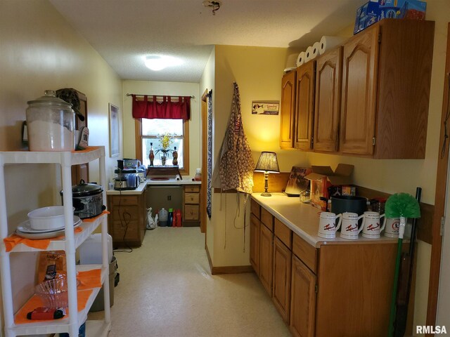 kitchen featuring brown cabinetry, stainless steel fridge with ice dispenser, and light countertops