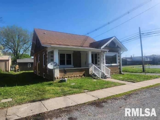 bungalow-style home with a front lawn and covered porch