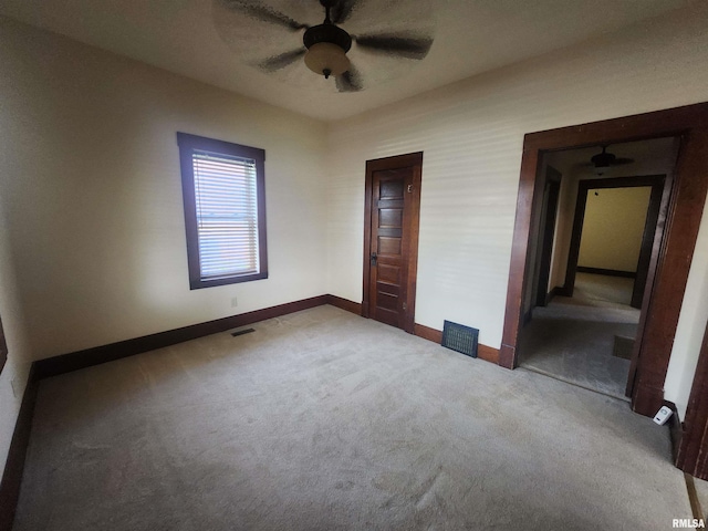 unfurnished bedroom featuring carpet floors, visible vents, baseboards, and ceiling fan