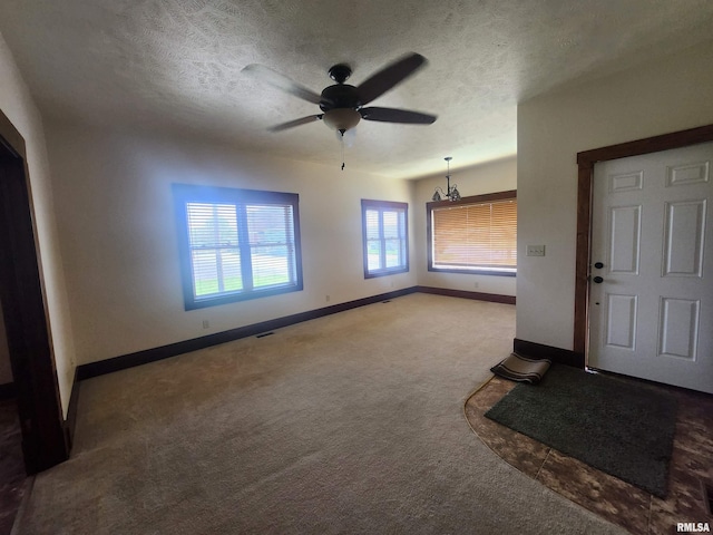 carpeted entrance foyer with baseboards, a ceiling fan, a textured ceiling, and visible vents