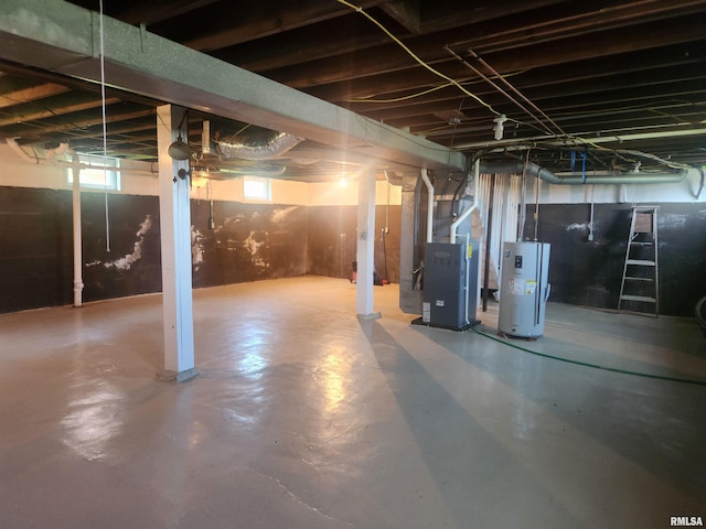 below grade area featuring heating unit and electric water heater