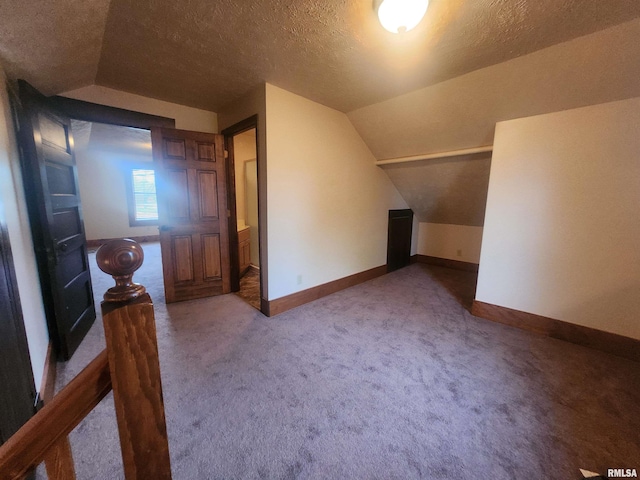 additional living space featuring lofted ceiling, baseboards, carpet flooring, and a textured ceiling