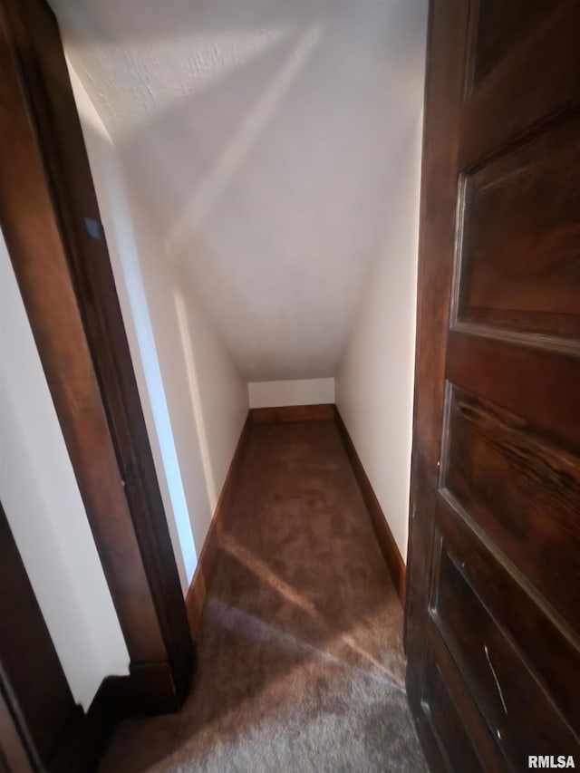 interior space featuring vaulted ceiling, carpet, and baseboards