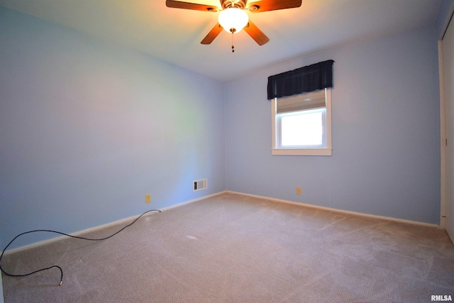 spare room with ceiling fan, baseboards, visible vents, and carpet
