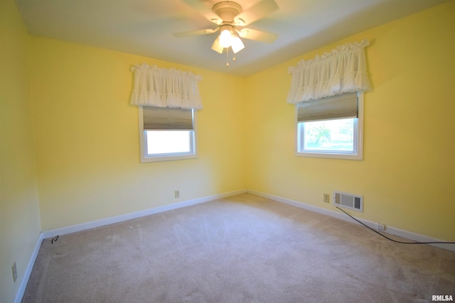 empty room featuring carpet flooring, visible vents, and plenty of natural light