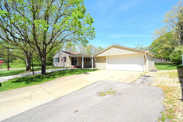 ranch-style home with driveway, a front yard, and a garage