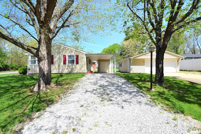single story home featuring driveway, a front yard, and a detached garage