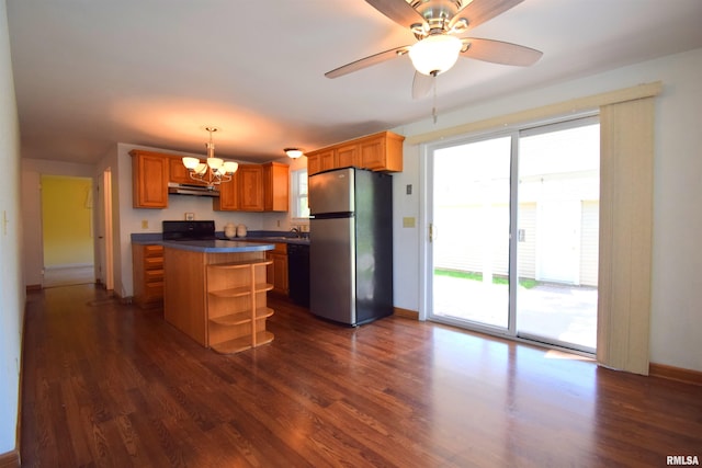 kitchen featuring under cabinet range hood, dark countertops, dishwasher, freestanding refrigerator, and range