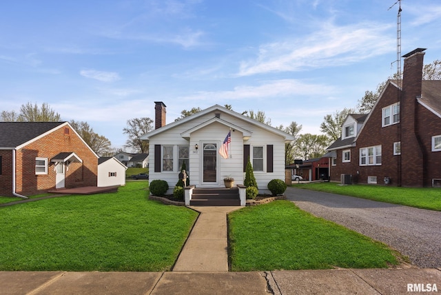 bungalow featuring a front lawn, a chimney, and cooling unit