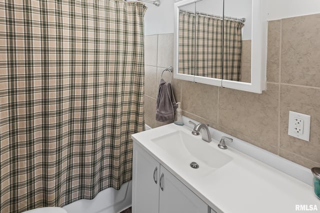 bathroom featuring tile walls, vanity, backsplash, and shower / tub combo