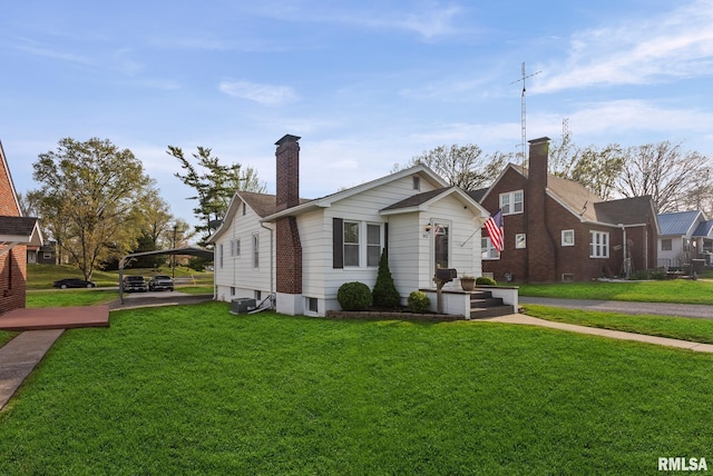 bungalow-style house featuring a chimney, a front lawn, and a detached carport