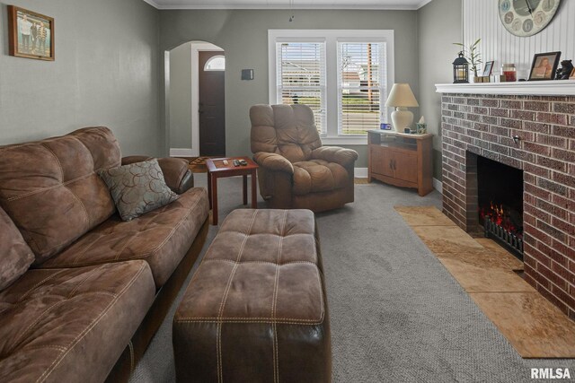 living area featuring arched walkways, a fireplace, ornamental molding, and light carpet