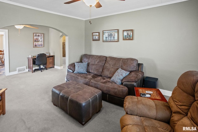 carpeted living area with crown molding, ceiling fan, arched walkways, baseboards, and visible vents