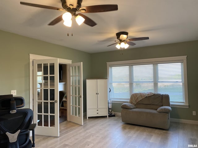 sitting room with a ceiling fan, baseboards, a wealth of natural light, and light wood-style flooring