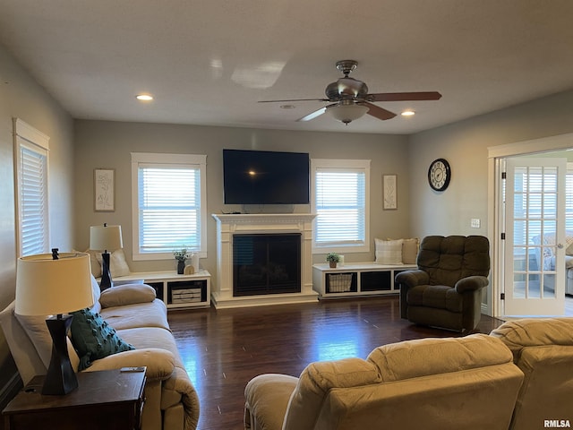 living area featuring recessed lighting, a glass covered fireplace, wood finished floors, and a ceiling fan