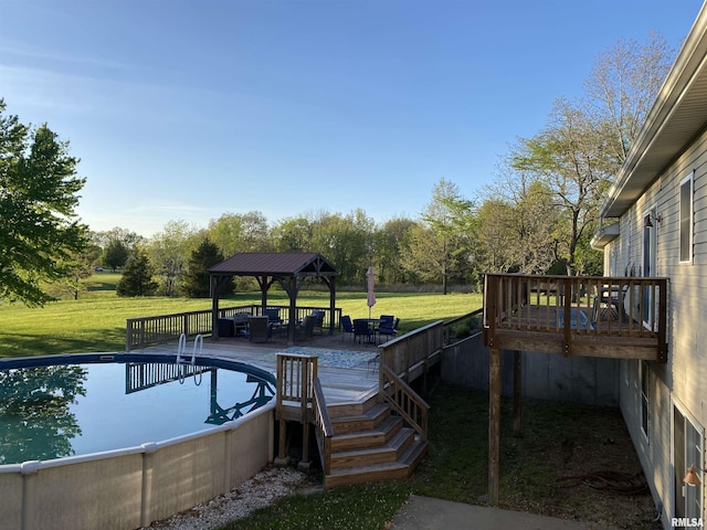 outdoor pool featuring a wooden deck, a gazebo, and a yard