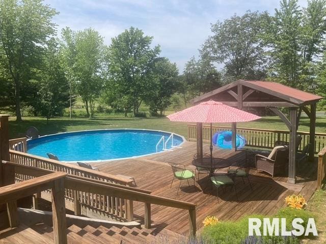 outdoor pool with a gazebo, a yard, and a deck