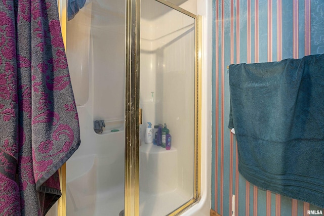 full bathroom featuring wallpapered walls and a stall shower