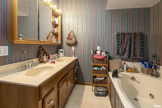 bathroom featuring wallpapered walls, tile patterned floors, a whirlpool tub, and a sink