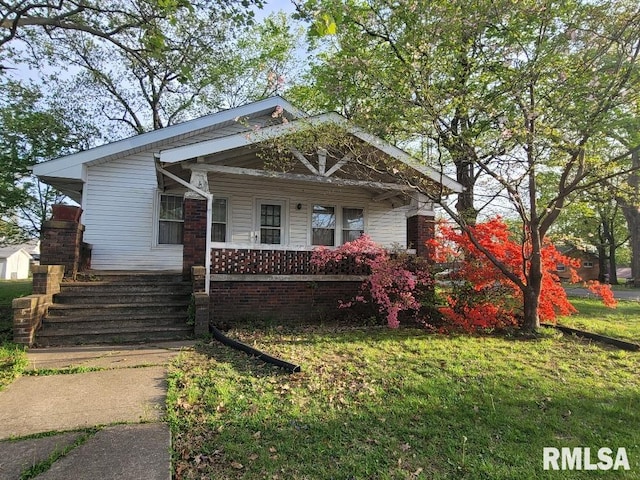 view of front of home with a porch and a front yard