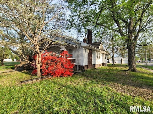 view of property exterior with a chimney and a yard