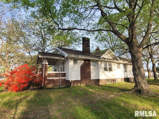 rear view of house featuring a chimney and covered porch