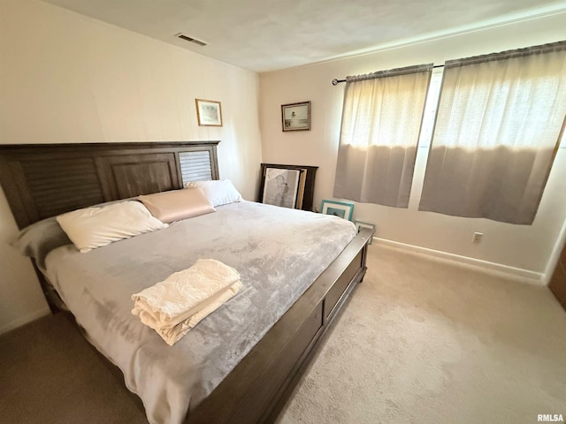 bedroom with visible vents, baseboards, and light carpet