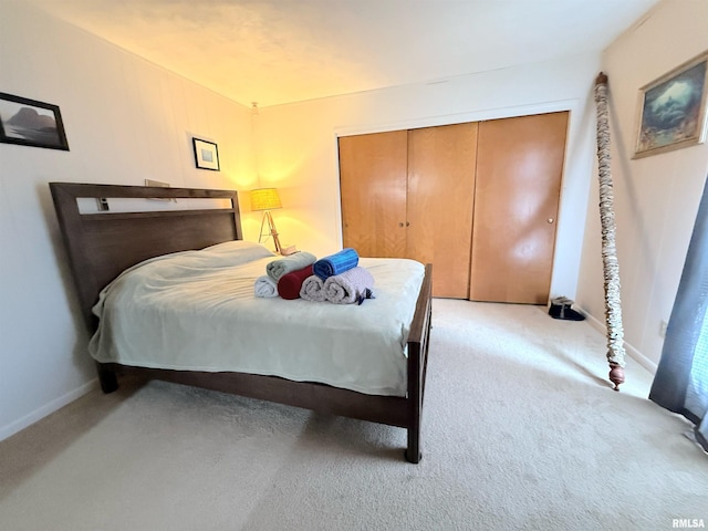 bedroom featuring a closet, baseboards, and light carpet