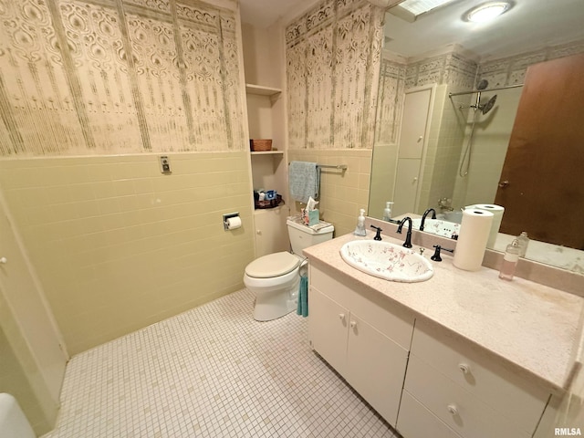 full bathroom featuring tile walls, tiled shower, tile patterned floors, toilet, and a wainscoted wall