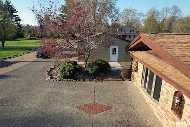 view of side of home featuring roof with shingles