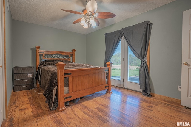 bedroom featuring a textured ceiling, wood finished floors, ceiling fan, and access to exterior