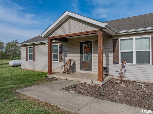 view of front of property featuring covered porch, a front yard, and roof with shingles
