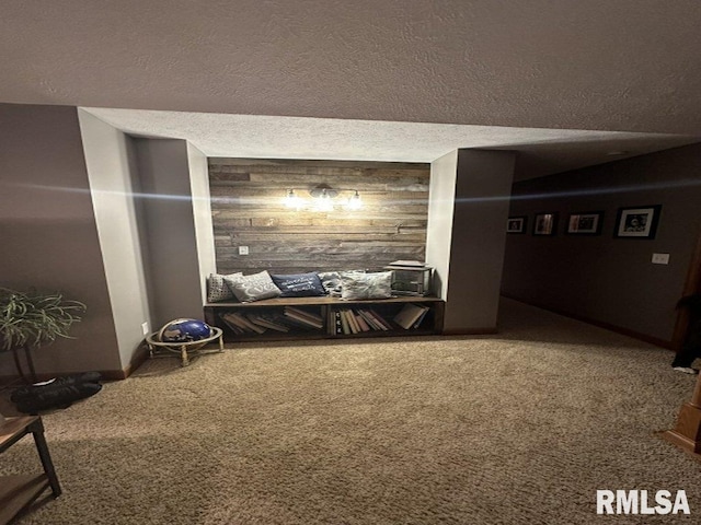 interior space featuring a textured ceiling, wooden walls, and carpet floors