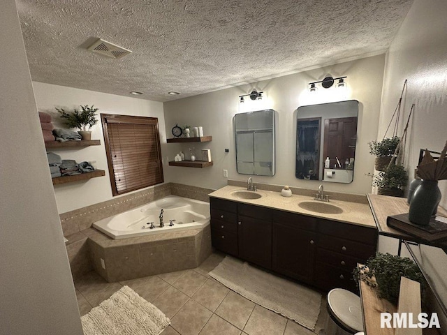 bathroom with tile patterned floors, visible vents, a bath, and a sink