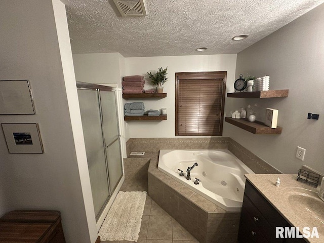 bathroom featuring tile patterned floors, a stall shower, visible vents, a textured ceiling, and a jetted tub