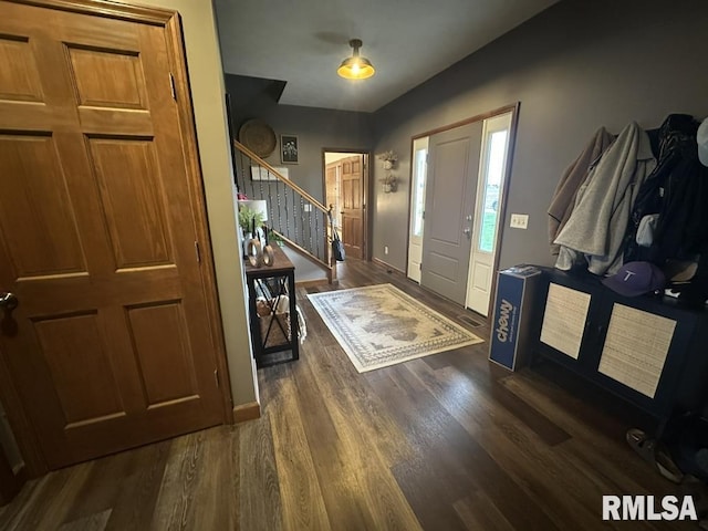 entryway featuring baseboards, wood finished floors, and stairs