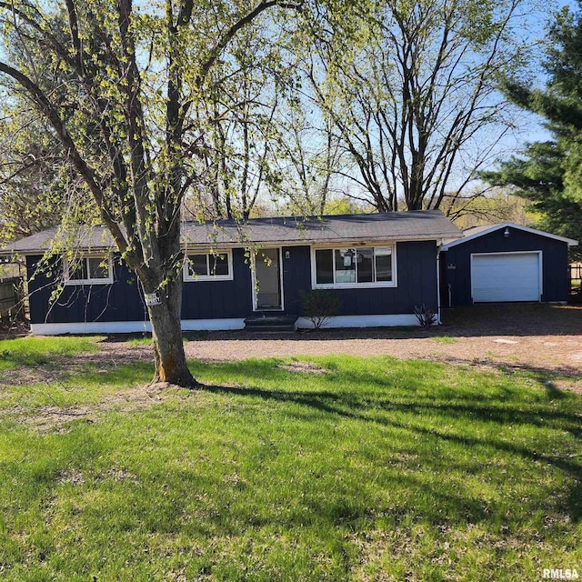 ranch-style home with driveway, an outdoor structure, board and batten siding, entry steps, and a front yard