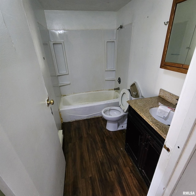 bathroom with toilet, vanity, washtub / shower combination, and wood finished floors