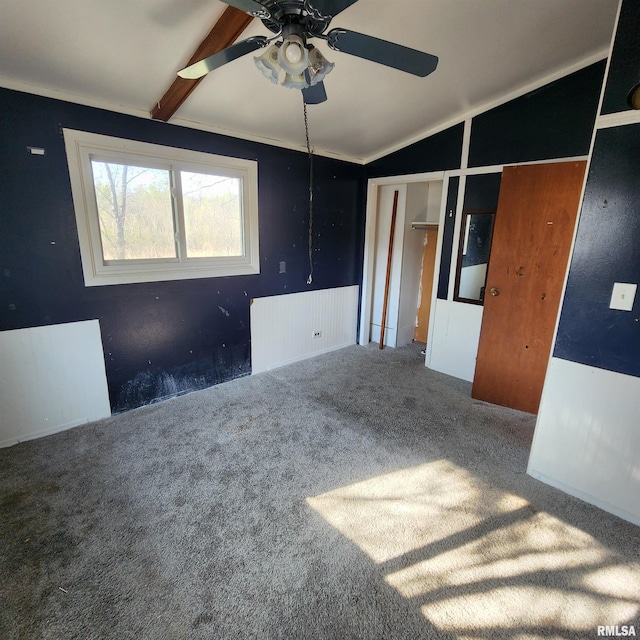 empty room featuring ceiling fan, carpet flooring, and vaulted ceiling