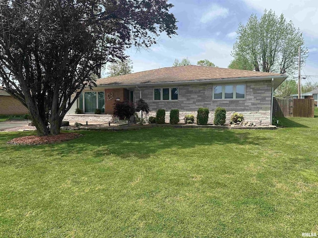 ranch-style home with a front lawn, stone siding, and fence