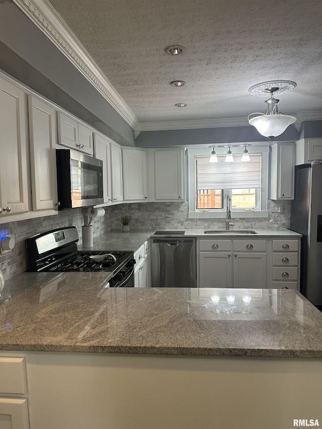 kitchen with stainless steel appliances, a textured ceiling, crown molding, and a sink