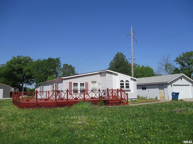 view of front facade featuring an outbuilding, a front lawn, a deck, and a garage