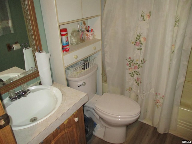 bathroom with toilet, shower / bathtub combination with curtain, wood finished floors, and vanity