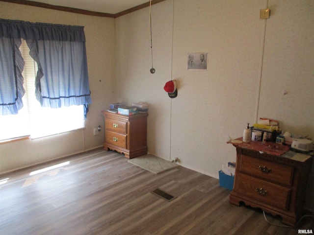 bedroom with visible vents, crown molding, and light wood finished floors