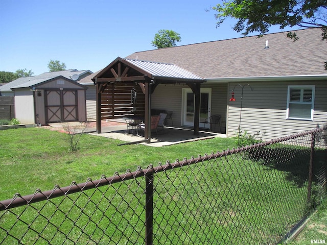 1607 Marion St, Carterville, IL 62918 - back of house with a storage unit, a patio area, a shingled roof, and an outbuilding