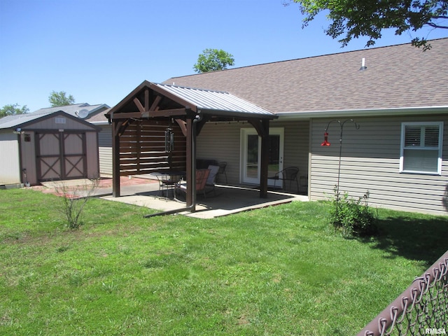 1607 Marion St, Carterville, IL 62918 - rear view of property with roof with shingles, a storage unit, a patio area, and a lawn